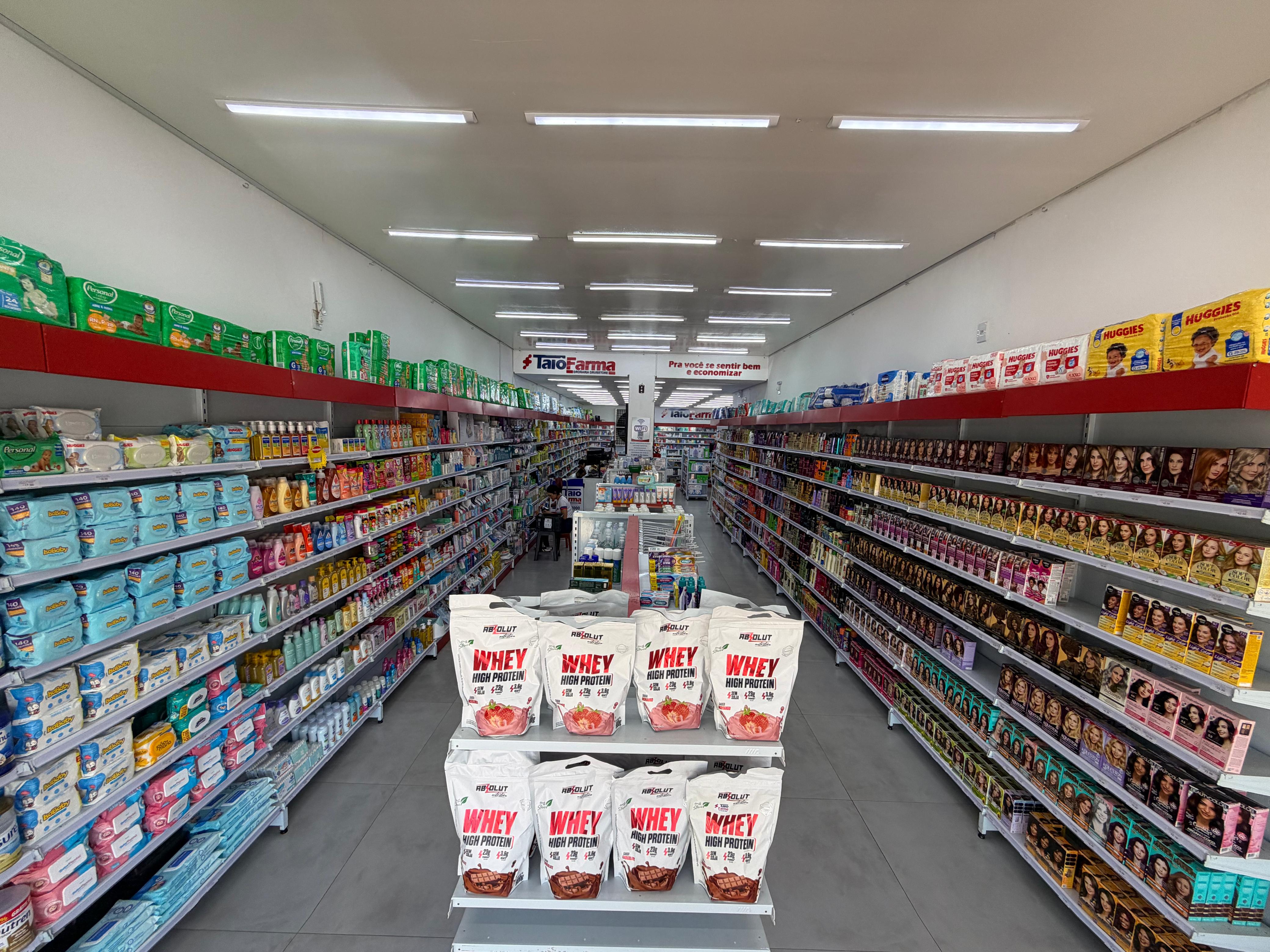 Corredor principal com produtos de higiene, suplementos e perfumaria
